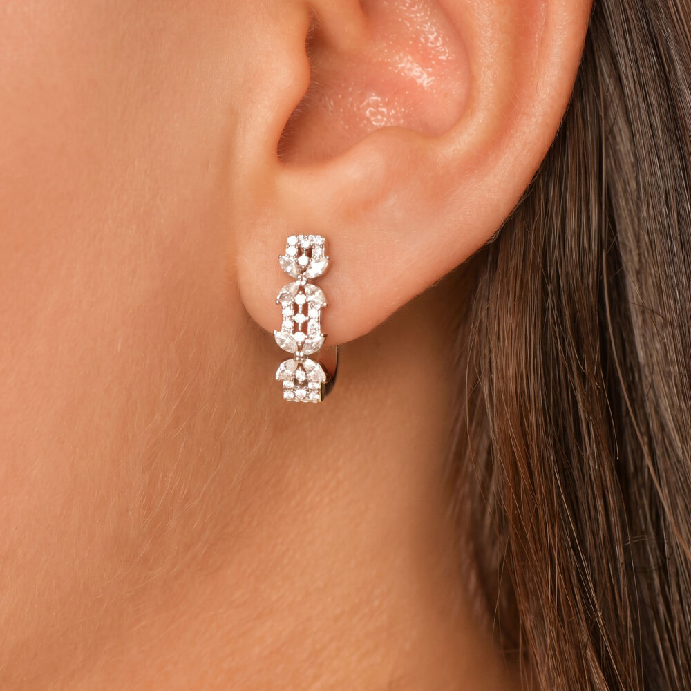 Femme portant des boucles d'oreilles feuilles en argent 925 à zircons