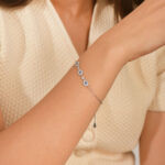 Femme portant un bracelet fleurs bleues en argent 925 à œil protecteur