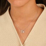 Femme portant un collier cercle fleur nacre en argent 925 avec papillon